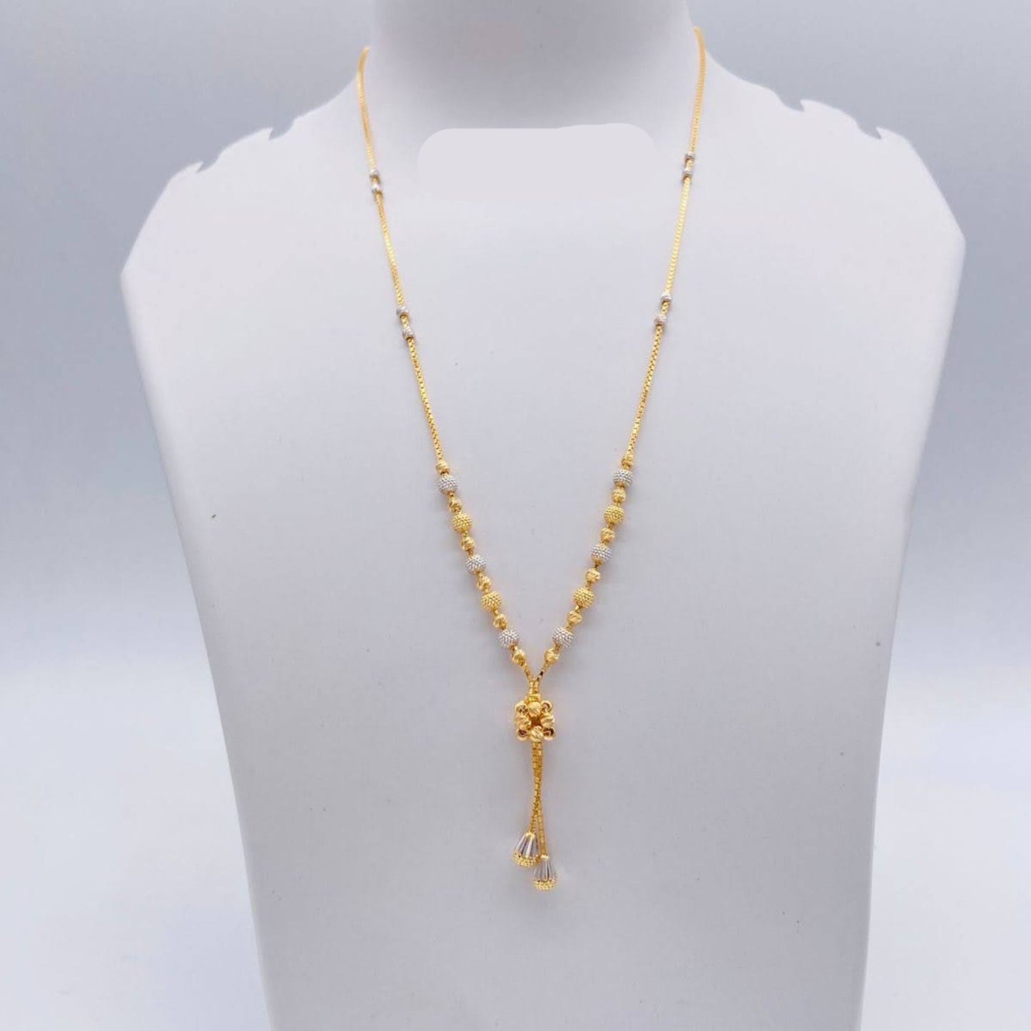 Gold necklace on a mannequin bust with weight indication