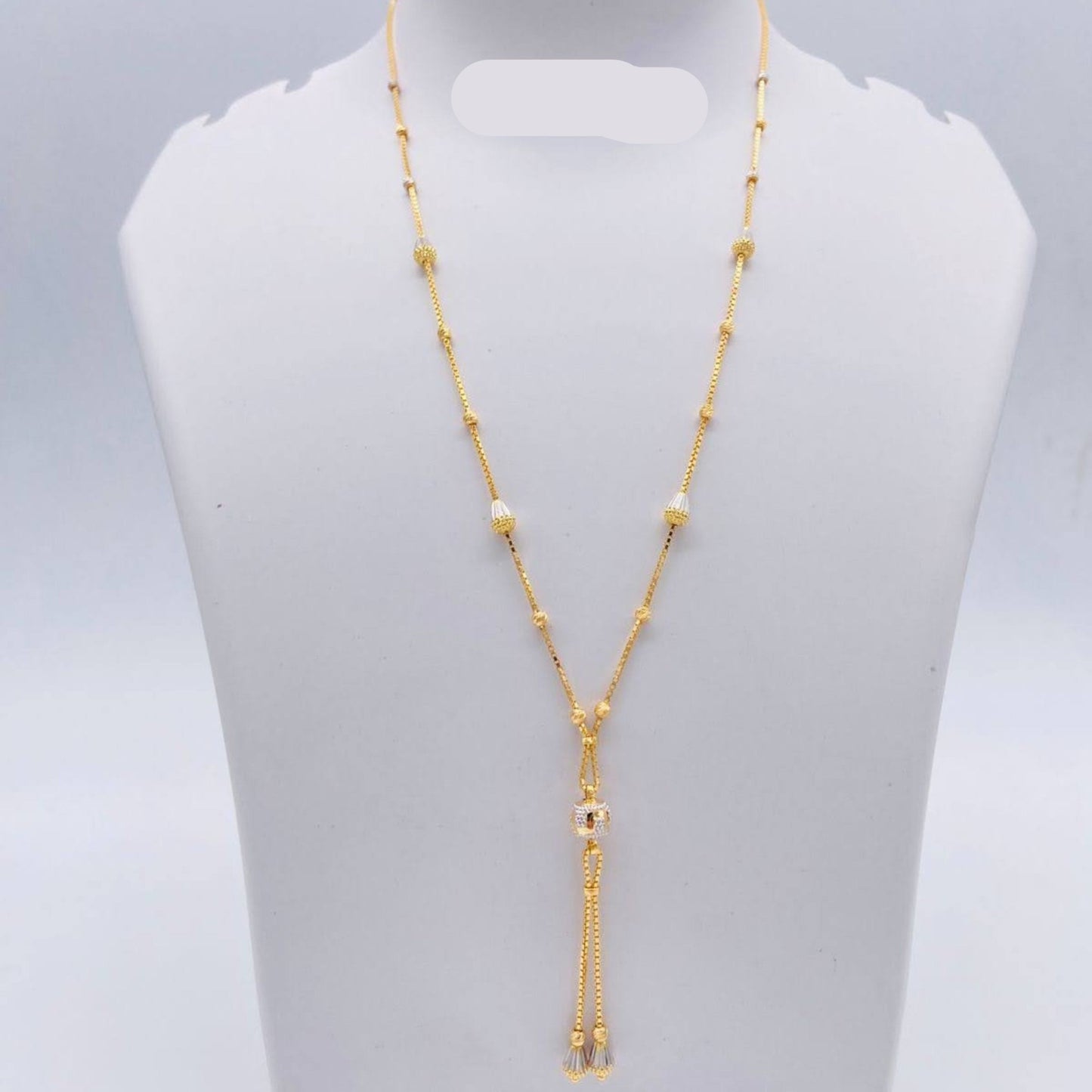 Gold necklace on a gray mannequin bust with weight indication