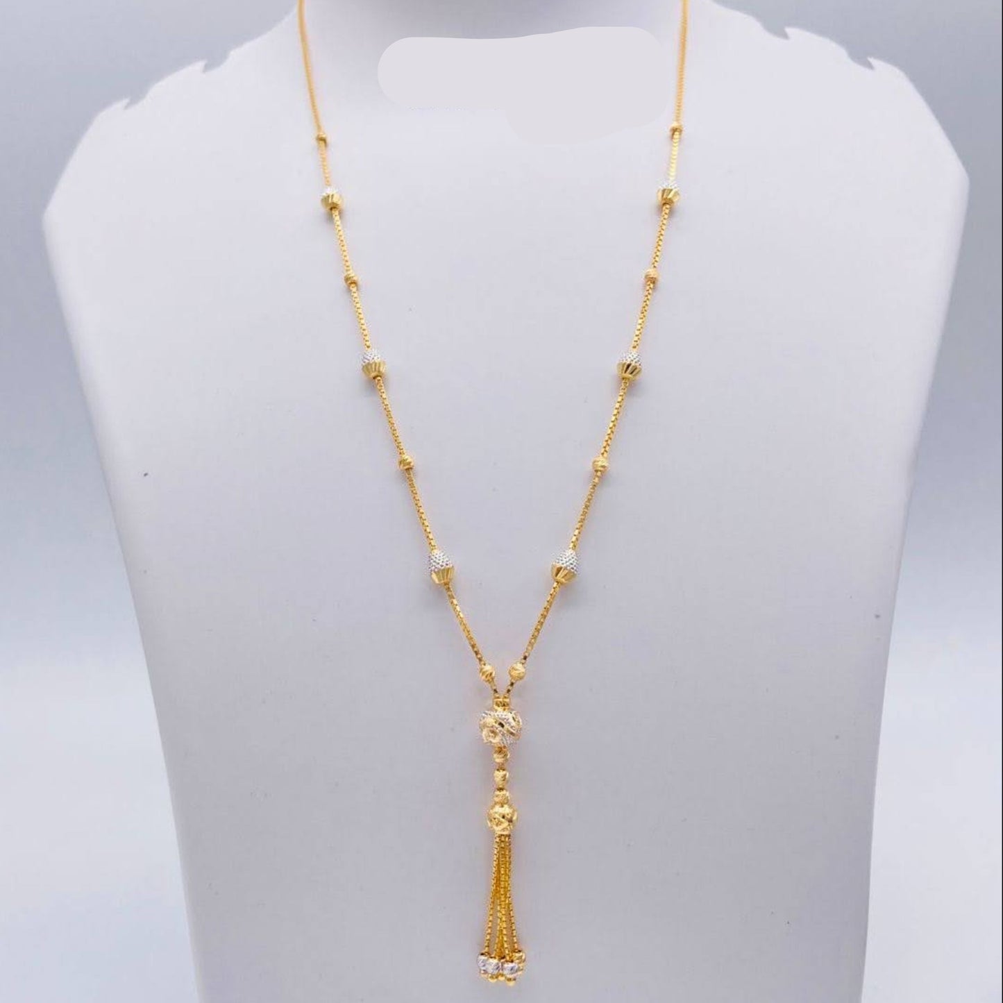 Gold necklace on a mannequin bust with weight indication