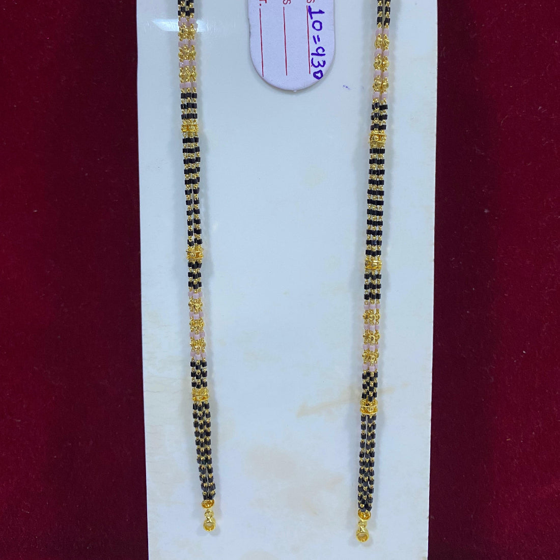 Two black and gold beaded bracelets on a white card with a visible brand tag.
