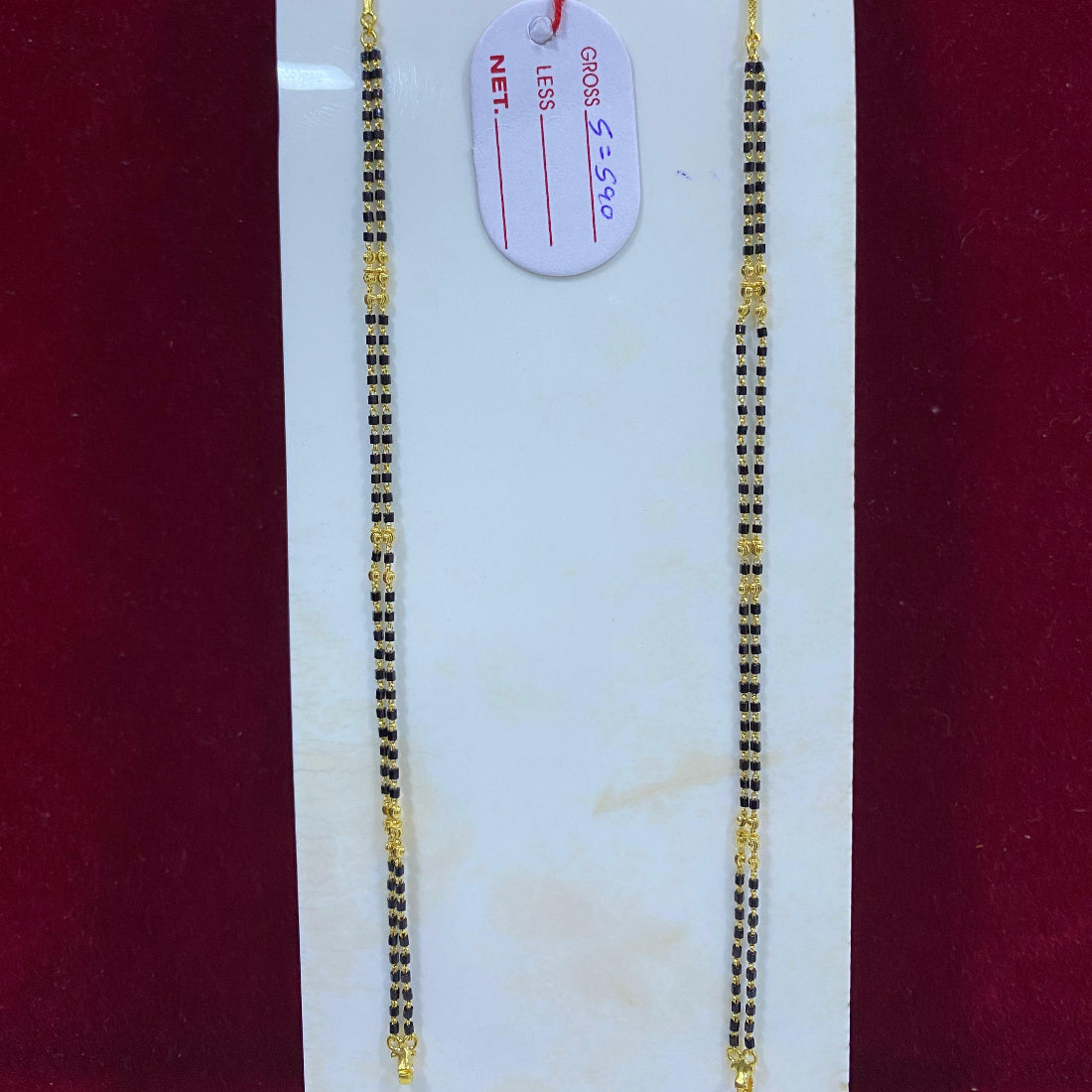 Two gold chains on a white card with a red background