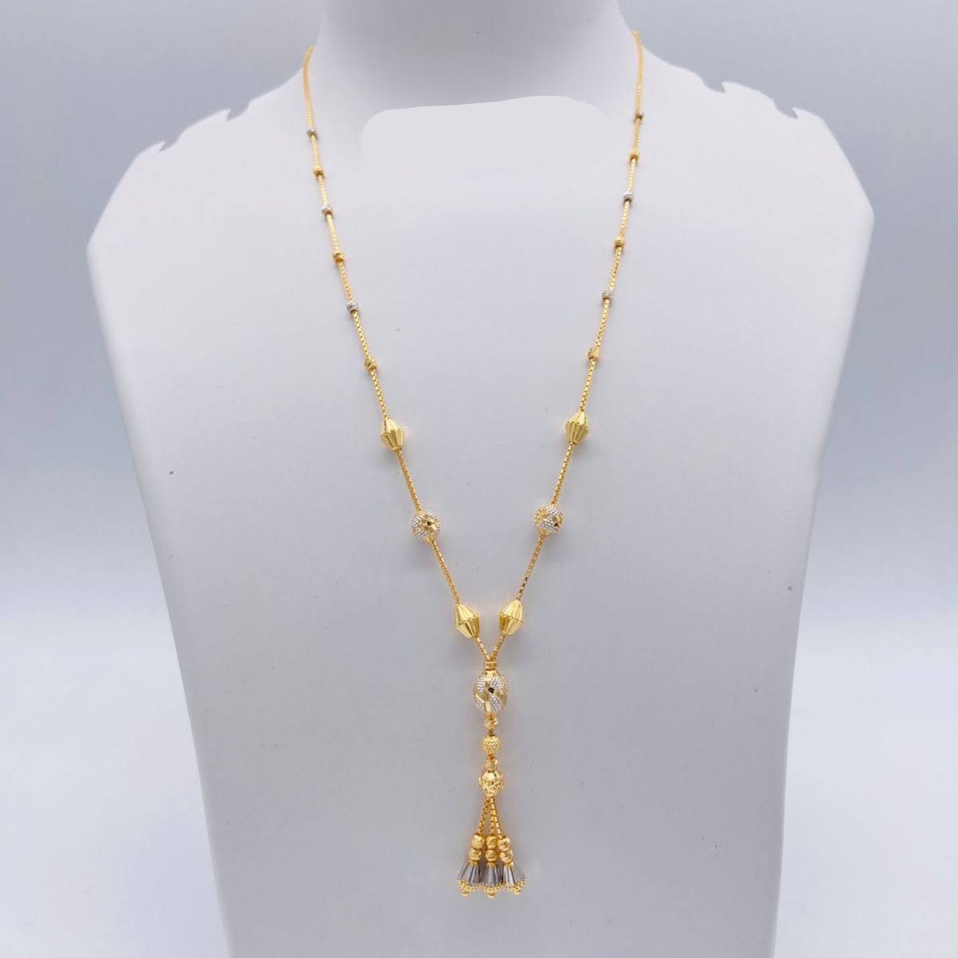 Gold necklace with tassel pendant on a mannequin bust, weight 7.770g, brand 'Sj221'.