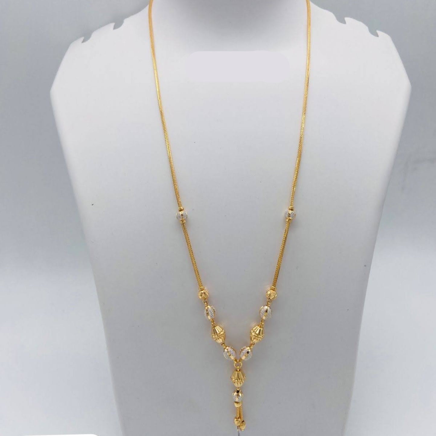 Gold necklace on a mannequin bust with weight displayed