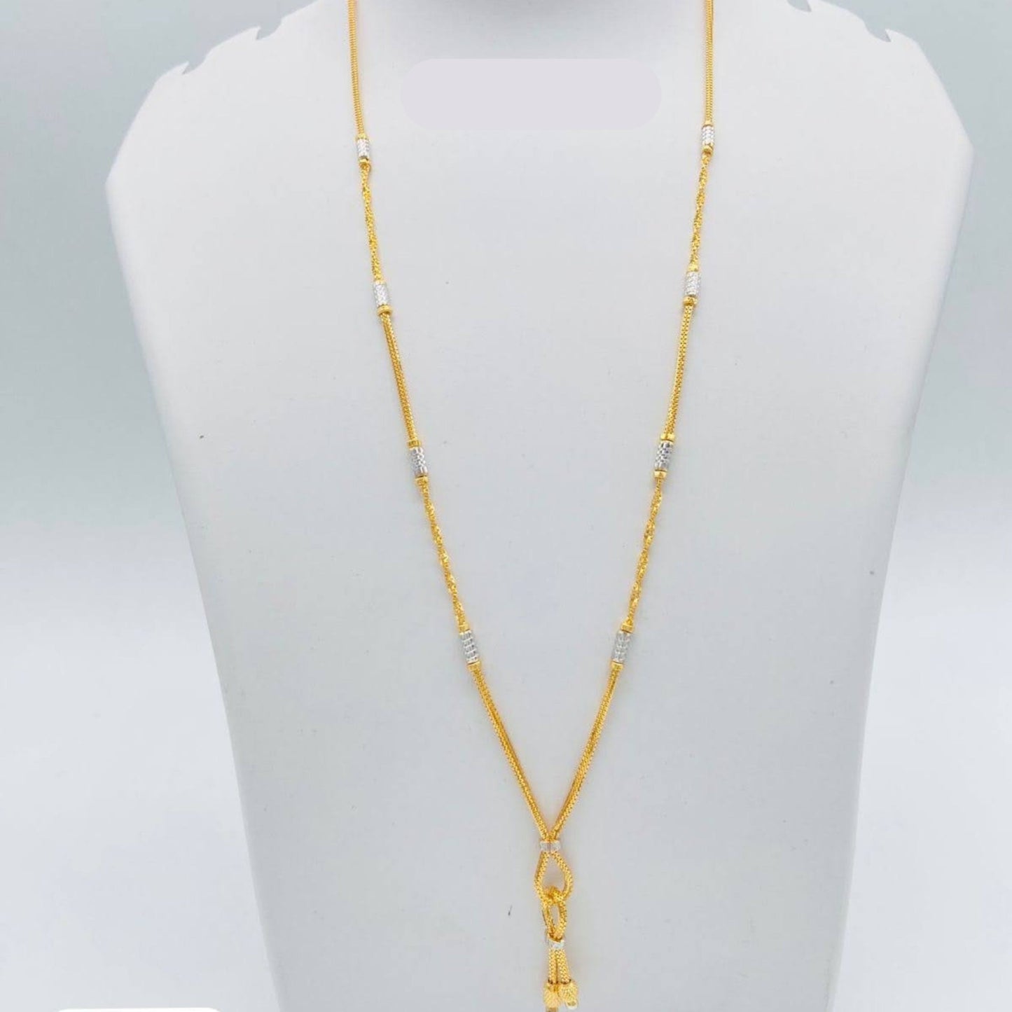 Gold necklace on a mannequin bust with dimensions displayed
