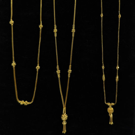 Three gold necklaces on a black stand