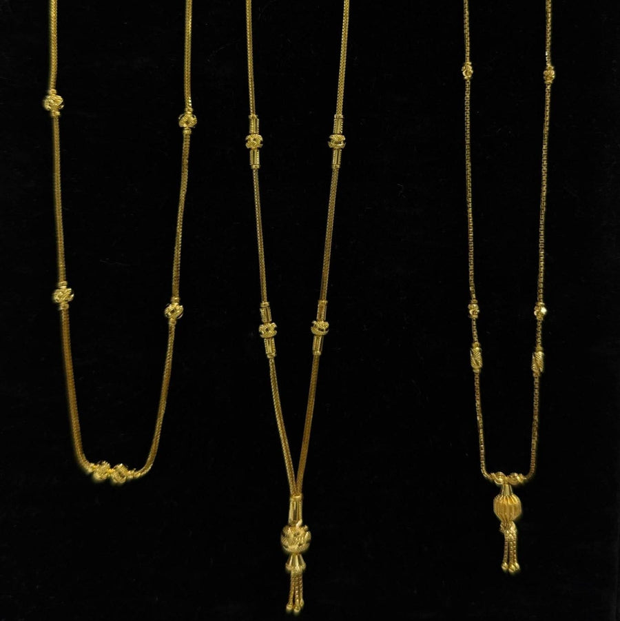 Three gold necklaces on a black stand