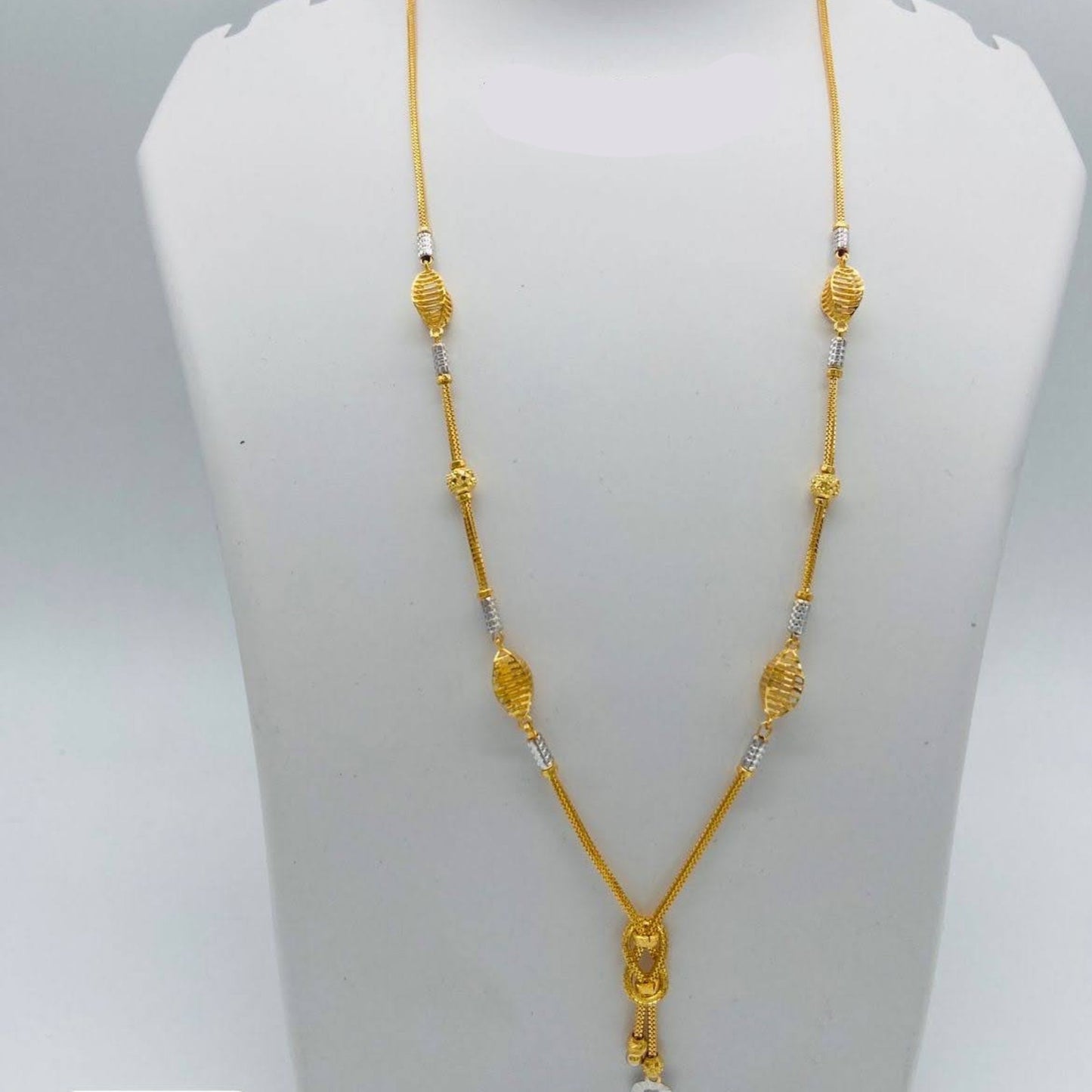 Gold necklace on a mannequin bust with weight and length information.