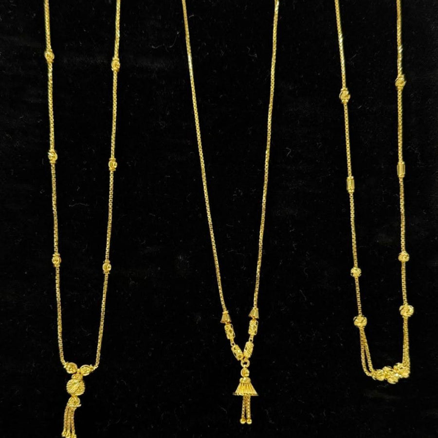 Three gold necklaces on a black display stand