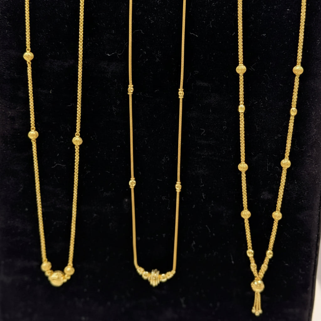 Three gold necklaces on a black stand