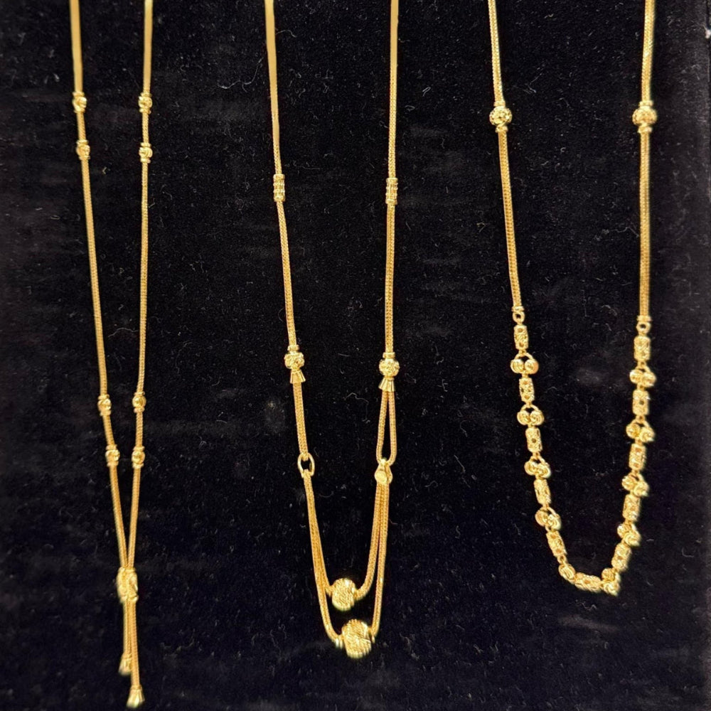 Three gold necklaces on a black stand