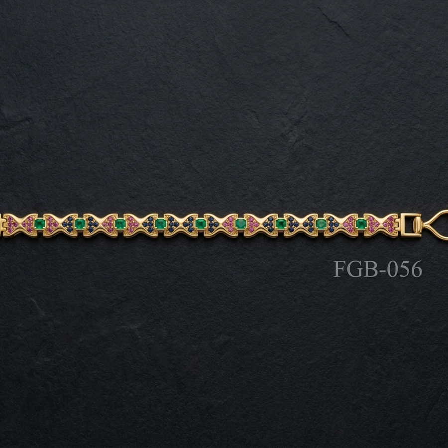 A gold-plated bracelet featuring a repeating pattern of green round-cut stones and pink enamel details, displayed horizontally on a dark textured slate background.