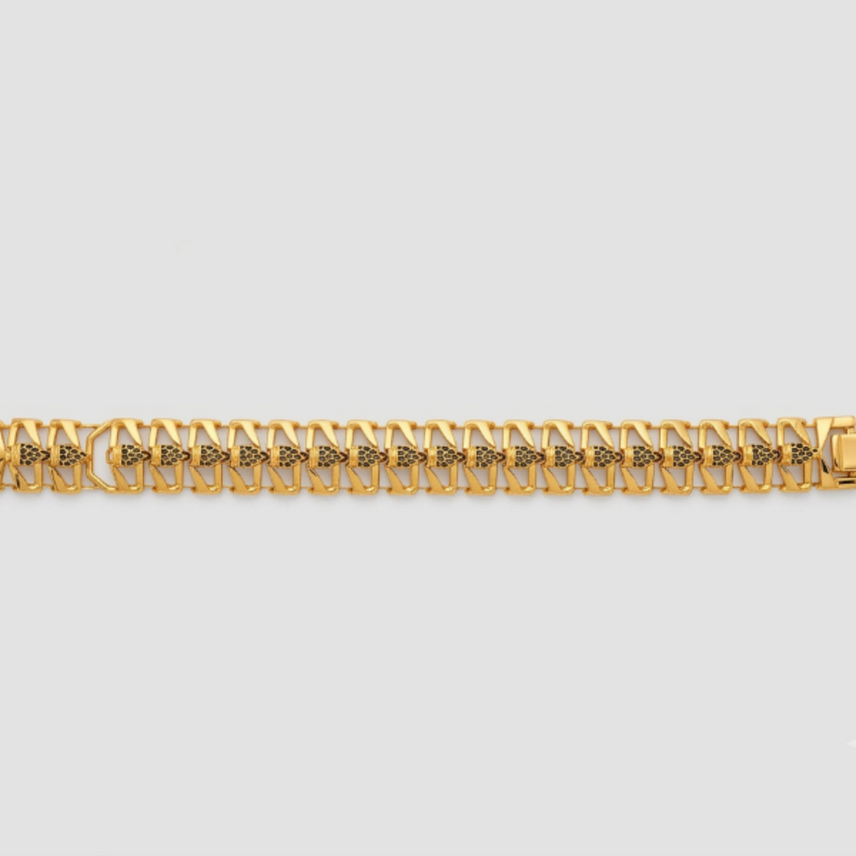 A gold-toned metal link bracelet with a repeating geometric pattern, displayed horizontally against a light gray background.