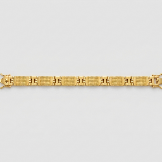 A gold link bracelet with a geometric pattern, displayed horizontally against a light gray background.