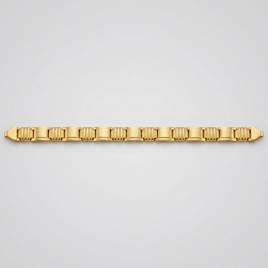 A gold tennis bracelet with a distinctive fluted or ribbed link design, displayed horizontally against a clean, light gray gradient background.