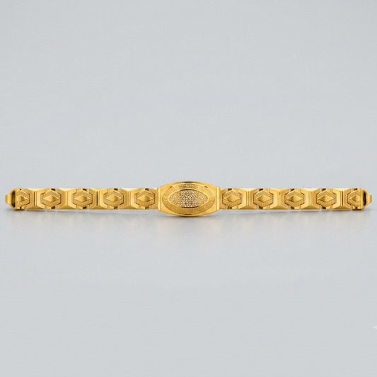 A gold-plated metal bracelet with a central oval medallion and repeating geometric links on either side, shown against a light gray background.