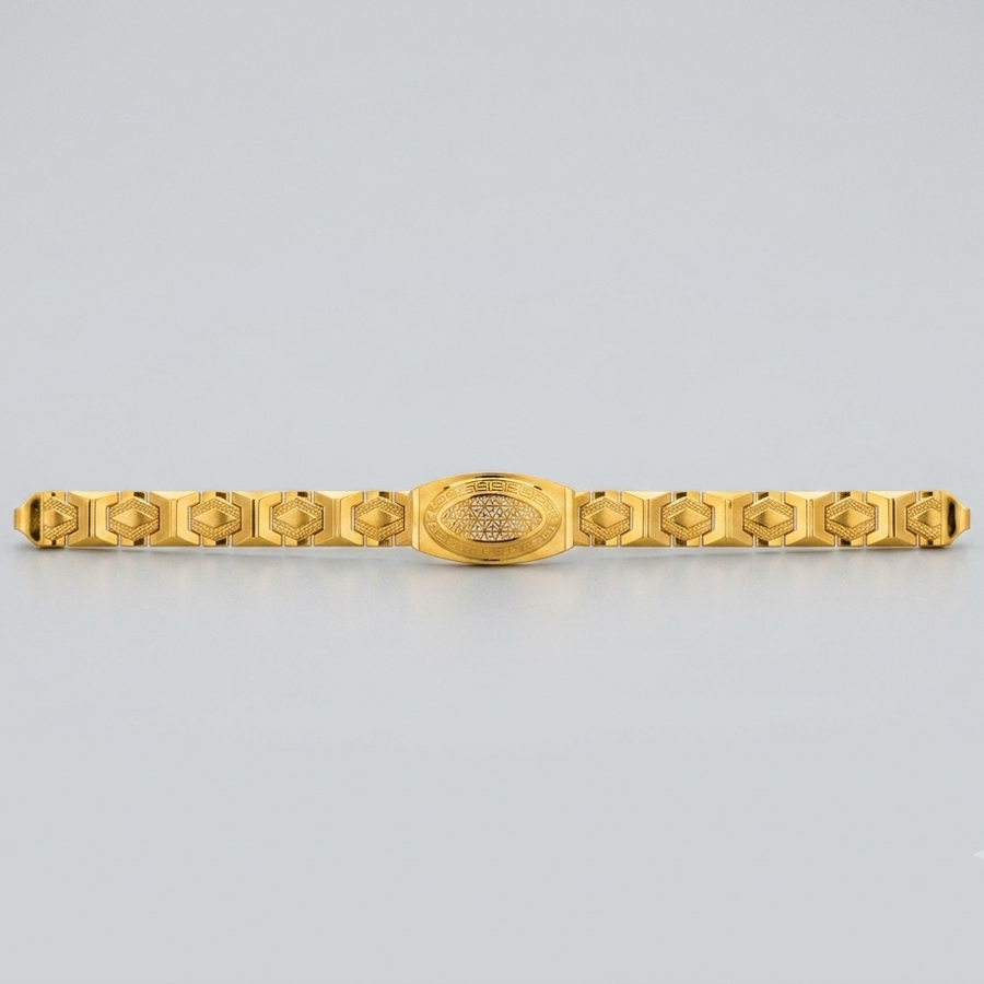 A gold-plated metal bracelet with a central oval medallion and repeating geometric links on either side, shown against a light gray background.