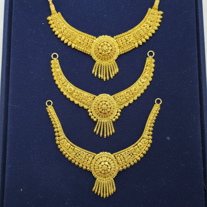 Three ornate gold-toned traditional necklace pieces displayed on a dark blue velvet background.