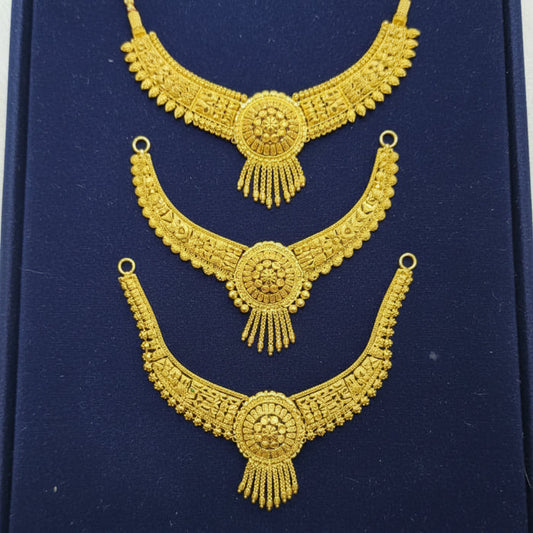 Three ornate gold-toned traditional necklace pieces displayed on a dark blue velvet background.