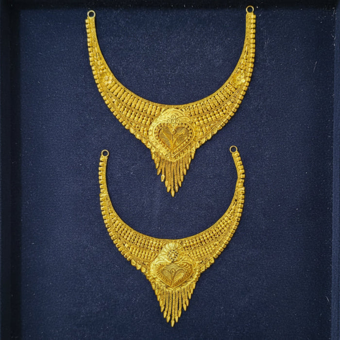 A pair of ornate gold-toned traditional necklace sets displayed on a dark navy blue textured background.