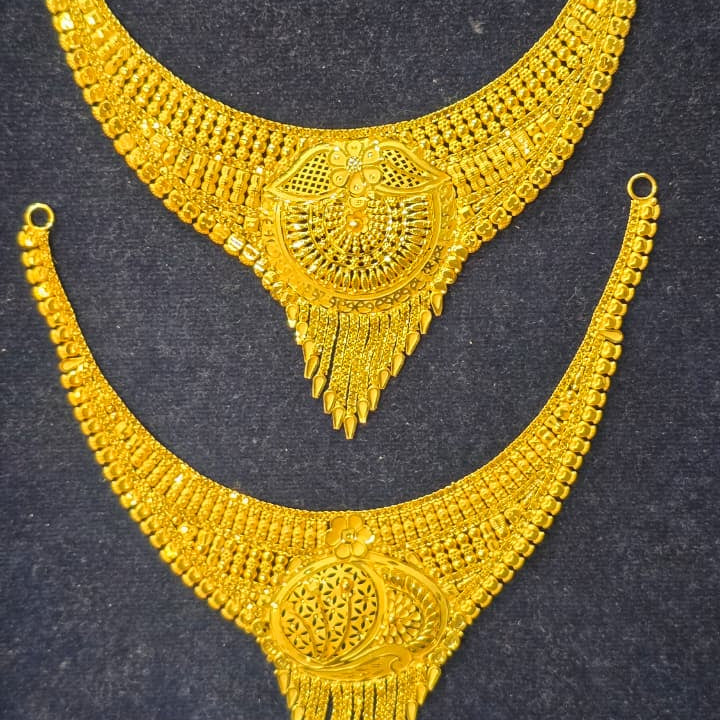 Two gold-toned traditional necklace pieces with intricate filigree and fringe details, displayed on a dark textured background.