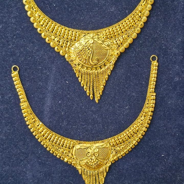 A pair of ornate gold crescent-shaped jewelry pieces with intricate filigree detailing and beaded edges, displayed on a dark blue textured background.