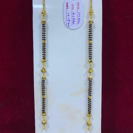 Two gold and black beaded necklaces on a white card with a red background