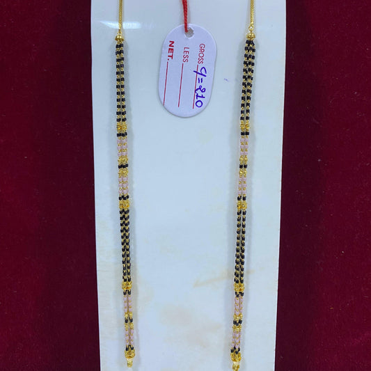 Two gold and black beaded necklaces on a white card with a red background