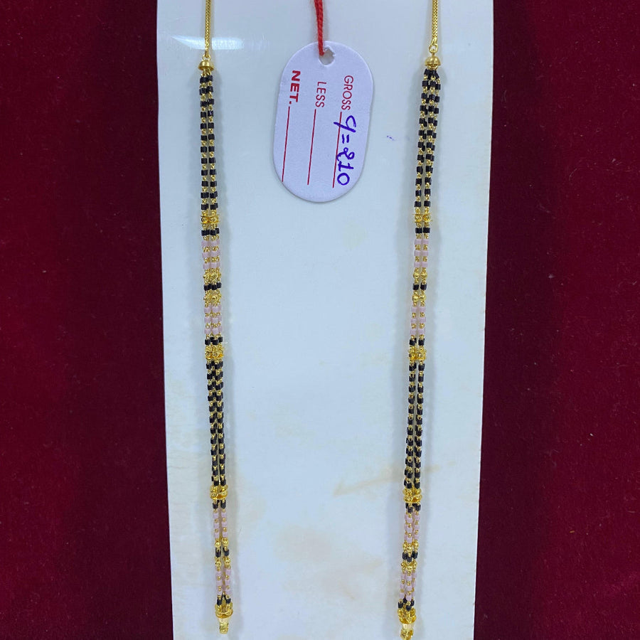 Two gold and black beaded necklaces on a white card with a red background