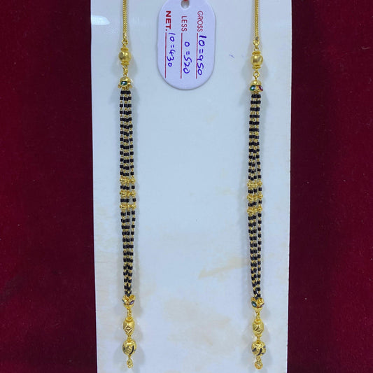 Two gold and black beaded necklaces on a white card with a red background