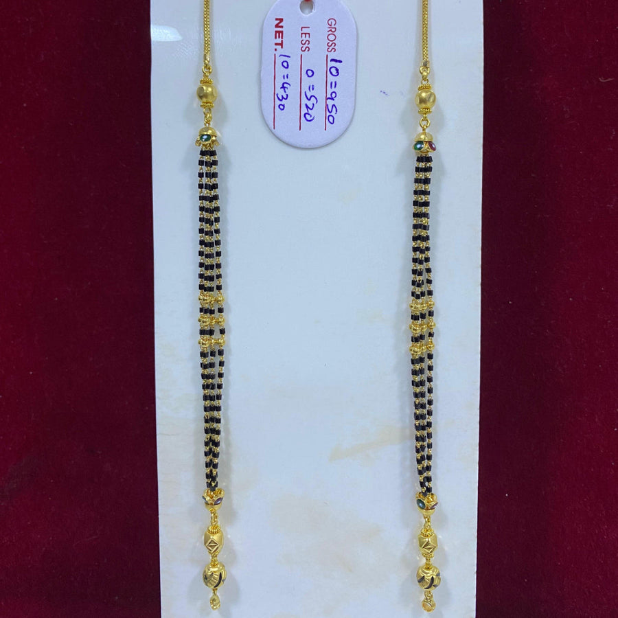 Two gold and black beaded necklaces on a white card with a red background