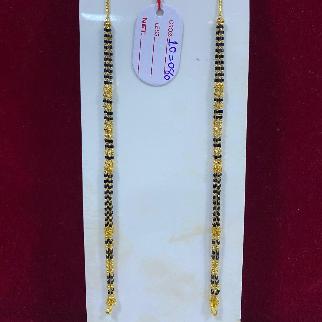 Two beaded necklaces on a white card with a red background