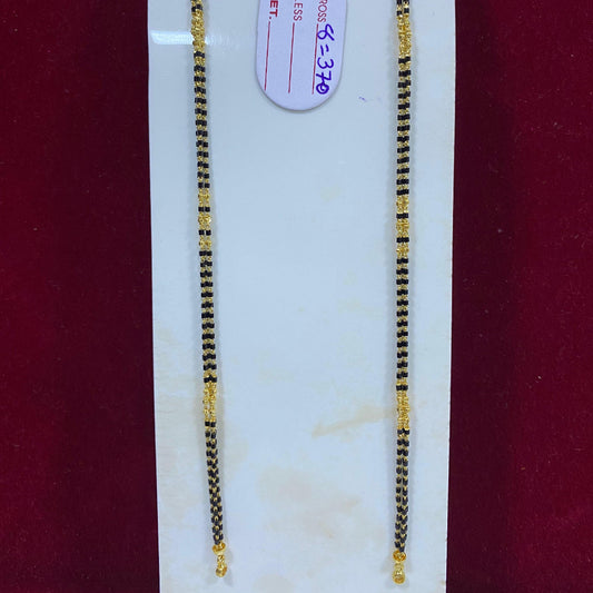 Two gold necklaces on a white stand with a red background