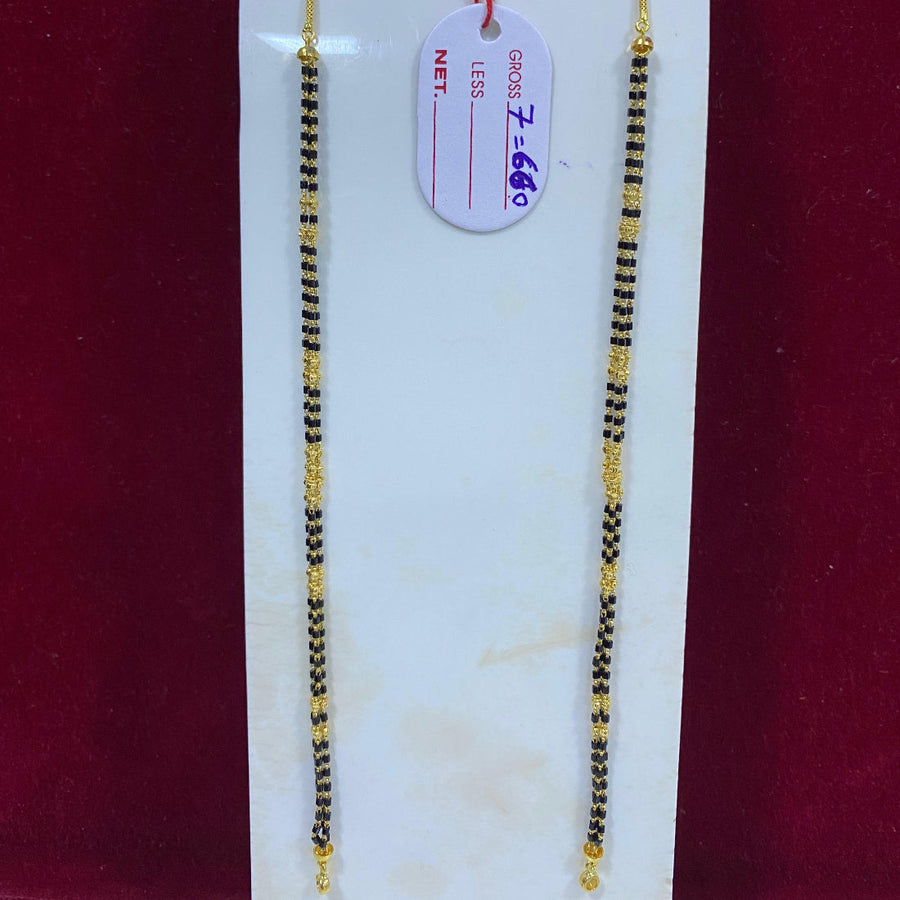 Two gold and black beaded necklaces on a white card with a red background