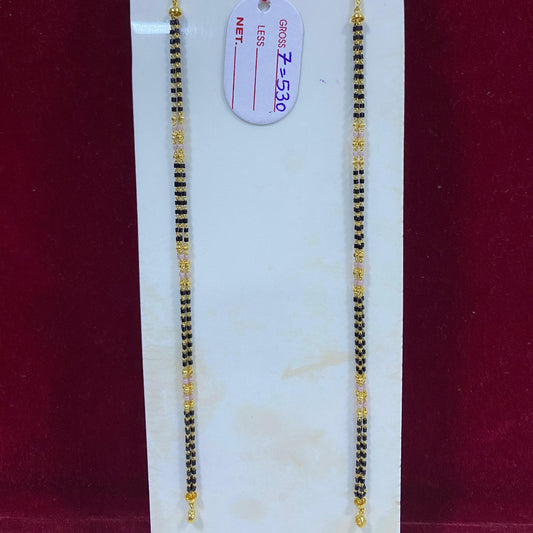 Two gold necklaces on a white card with a red background
