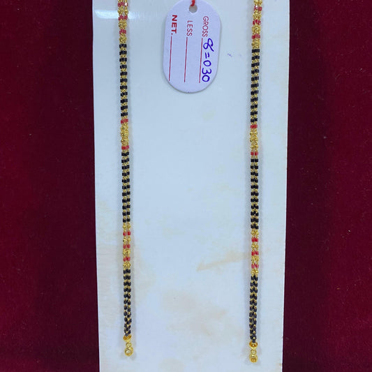 Two black and gold beaded bracelets on a white card with a price tag against a red background.