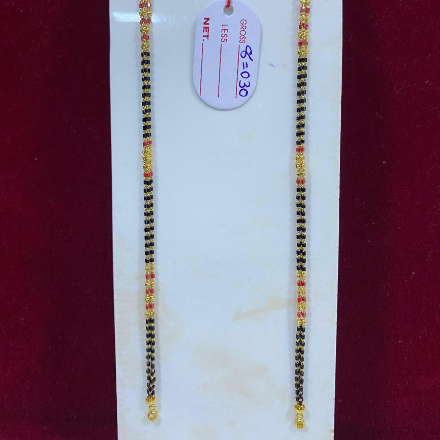 Two black and gold beaded bracelets on a white card with a price tag against a red background.
