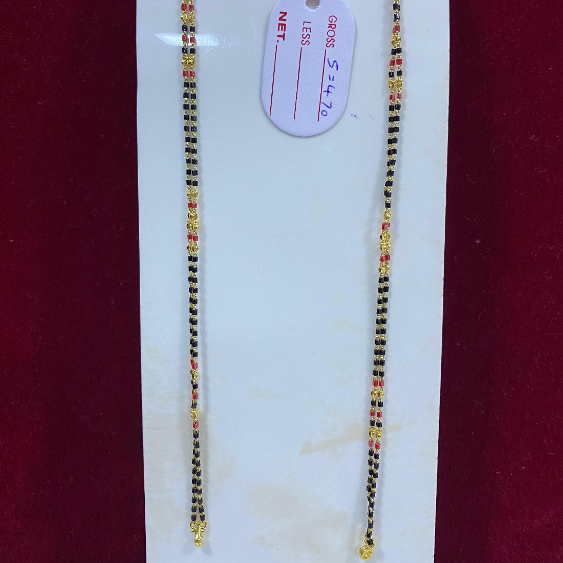 Two beaded necklaces on a white card with a red background