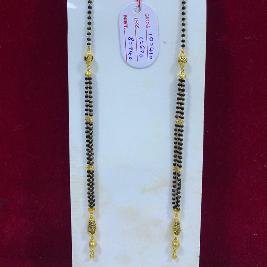 Two gold and black beaded necklaces on a white card with a red background