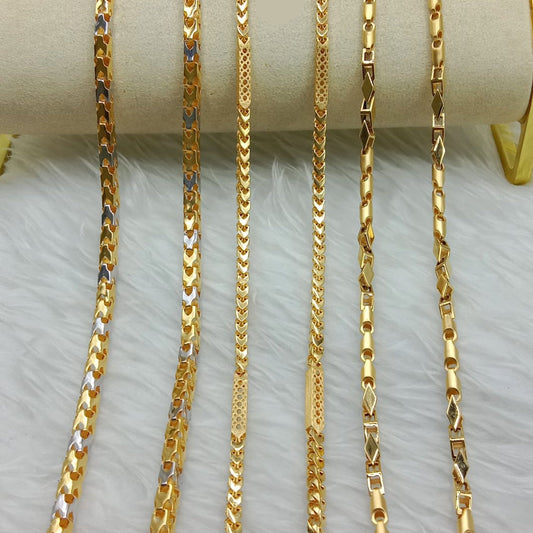 Gold chains of different lengths displayed on a white surface