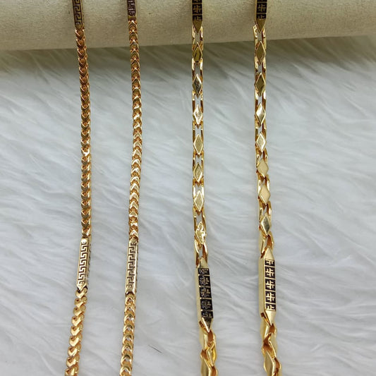 Three gold chains of different lengths on a white surface
