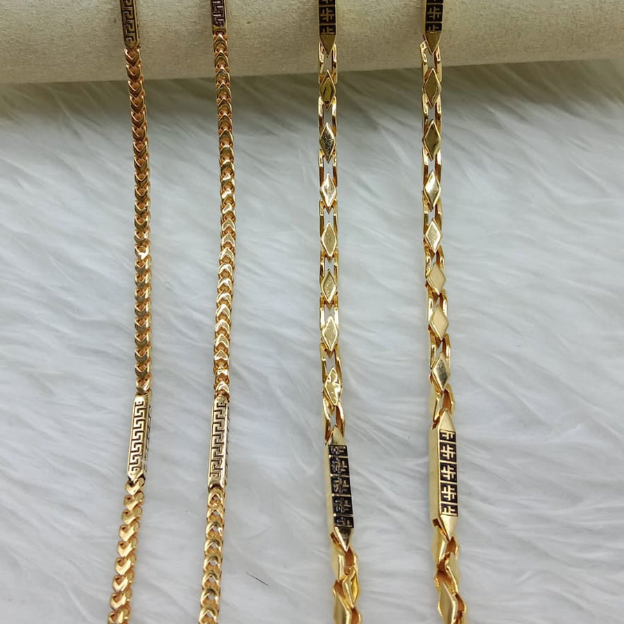 Three gold chains of different lengths on a white surface