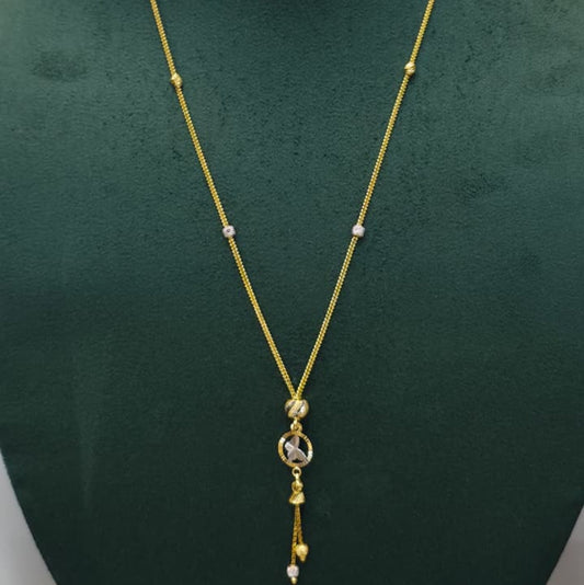 A gold chain necklace with a circular pendant and dangling tassels, displayed on a dark green velvet jewelry bust against a light gray background.