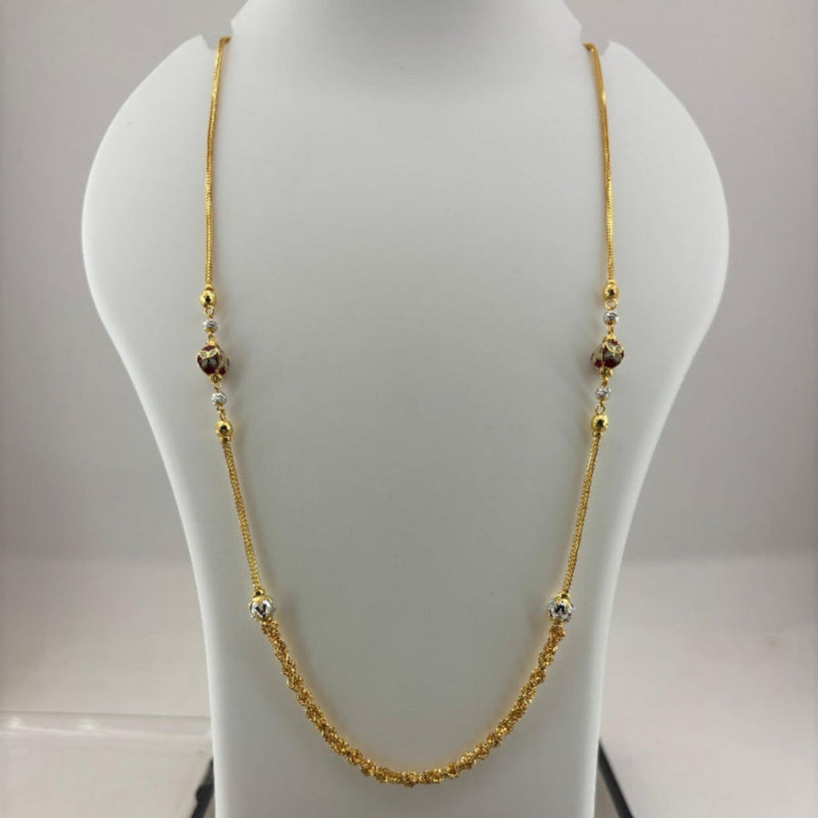 A gold chain necklace with small decorative beads displayed on a white jewelry bust, with a digital scale visible underneath.