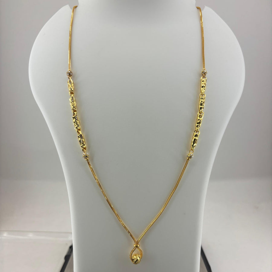A gold necklace with a teardrop pendant displayed on a white mannequin bust, with a digital scale underneath showing a weight of 8.14 grams.