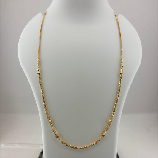 A gold chain necklace displayed on a white mannequin bust, with a digital scale visible underneath. The scale screen shows a weight reading of 8.