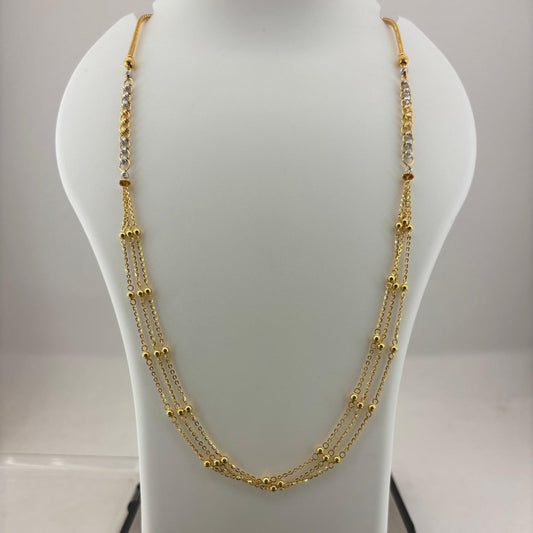 A multi-strand gold necklace displayed on a white mannequin bust, with a digital scale visible underneath to show the weight.