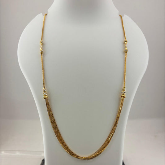 A gold chain necklace displayed on a white mannequin bust, with a digital scale visible underneath.