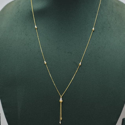 A delicate gold necklace displayed on a dark green velvet jewelry bust. The necklace features a fine chain with small spaced gold beads and a central teardrop-shaped gold pendant from which a short chain dangles.
