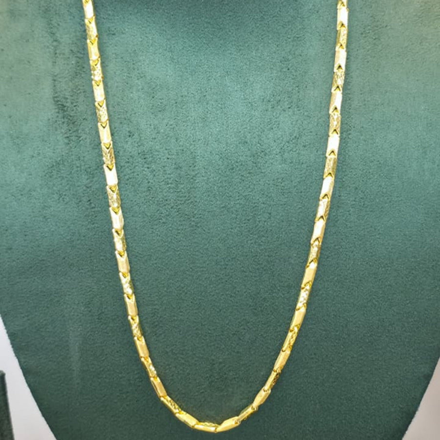 A gold chain necklace displayed on a dark green velvet jewelry bust against a plain light background.