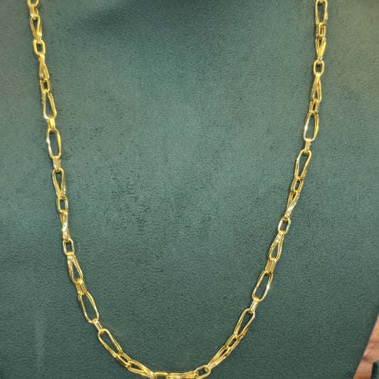 A gold-colored Figaro chain necklace displayed on a dark green velvet jewelry bust.